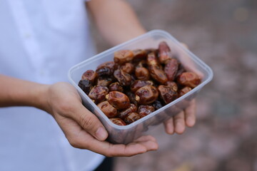 man holding a container of dried dates