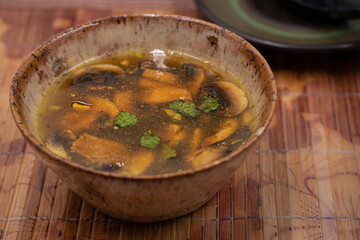 Ginger garlic soup with mushrooms in traditional Asian bowl