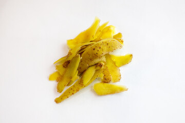 Close-up of a small pile of freshly peeled potato skins on a white surface