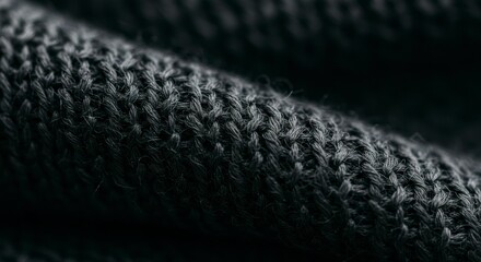 Close-up view of textured dark fabric showcasing intricate knitting patterns and soft fibers