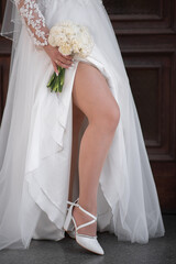 bride with a bouquet and wedding white shoes