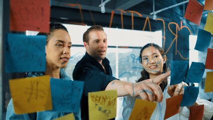 Portrait of professional diverse business team brainstorming marketing idea on colorful sticky...