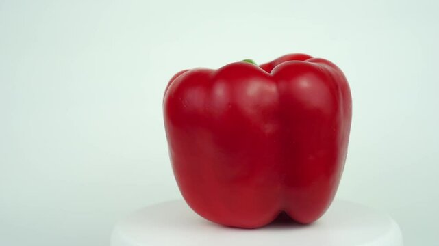 Big red bell pepper rotating close-up on a white background