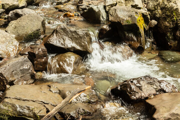 a small waterfall in the mountains among the rocks