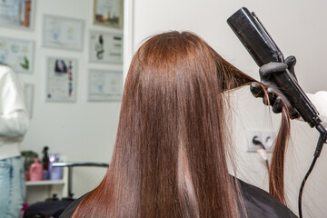 Fototapeta premium Beautiful young woman with long brown hair in a beauty salon.