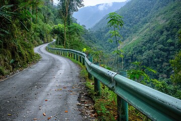 A winding mountain road cuts through lush green rainforest, offering breathtaking views of the valley below.