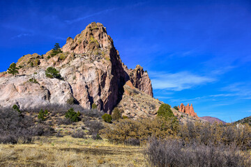 2024 12-21 JAGGED MOUNTAIN WITH A BRIGHT BLUE SKY AND FOLIAGE IN THE FOREGROUND AT THE VALLEY OF THE GODS NEAR COLORADO SPRINGS COLORADO