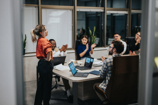 Multicultural group of business people engaged in a late-night brainstorming session in a modern office, discussing strategies and solutions for growth. - Powered by Adobe