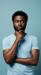 Obraz premium ** Contemplative Man: Deep in Thought Portrait - African American Model, Thinking Face, Light Blue T-Shirt & Background