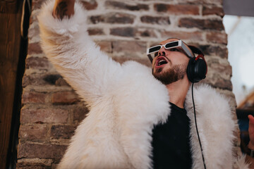 A man dressed in a white fur coat and sunglasses passionately enjoying music inside a cozy...