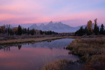 Serene Mountain Landscape with Mirror-Like Reflection of Peaks at Sunrise

