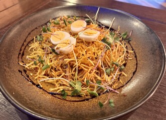 Salad with pork and potato pie in a brown plate on the table in the restaurant. Delicious food. Close-up