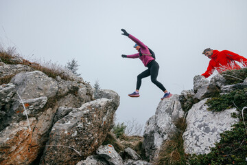 Fototapeta premium Trail running couple man and woman running on a mountain path