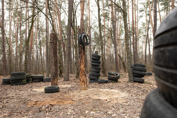 A unique outdoor sports ground with various tires set up for training. The area is surrounded by trees, providing a natural and tranquil environment for fitness enthusiasts