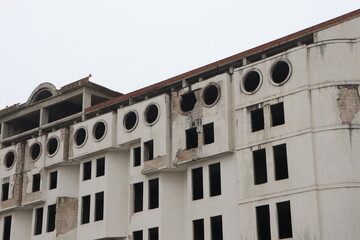 Fototapeta premium An Abandoned Building Featuring a Distressed Facade Accompanied by Unique Circular Windows