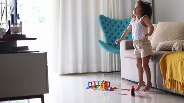 menina dan&ccedil;ando em frente a tv da sala
