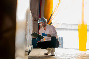 Inspector with clipboard supervising palletized goods in a storage facility Emphasis on quality...