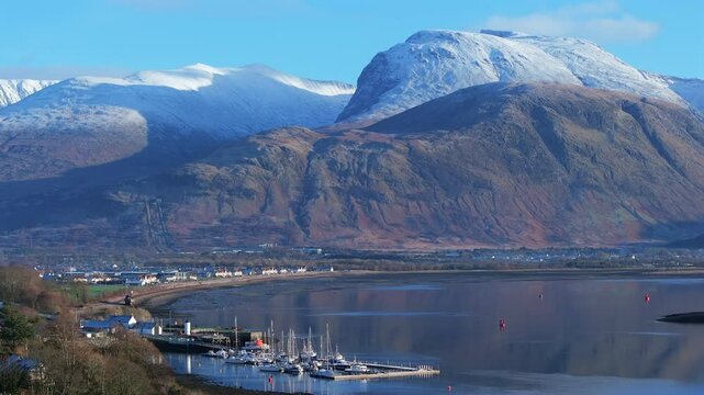 Corpach lighthouse and marina on the shores of Loch Eli with snow capped Ben Nevis and Fort William, Highland region, Scotland, United Kingdom 
