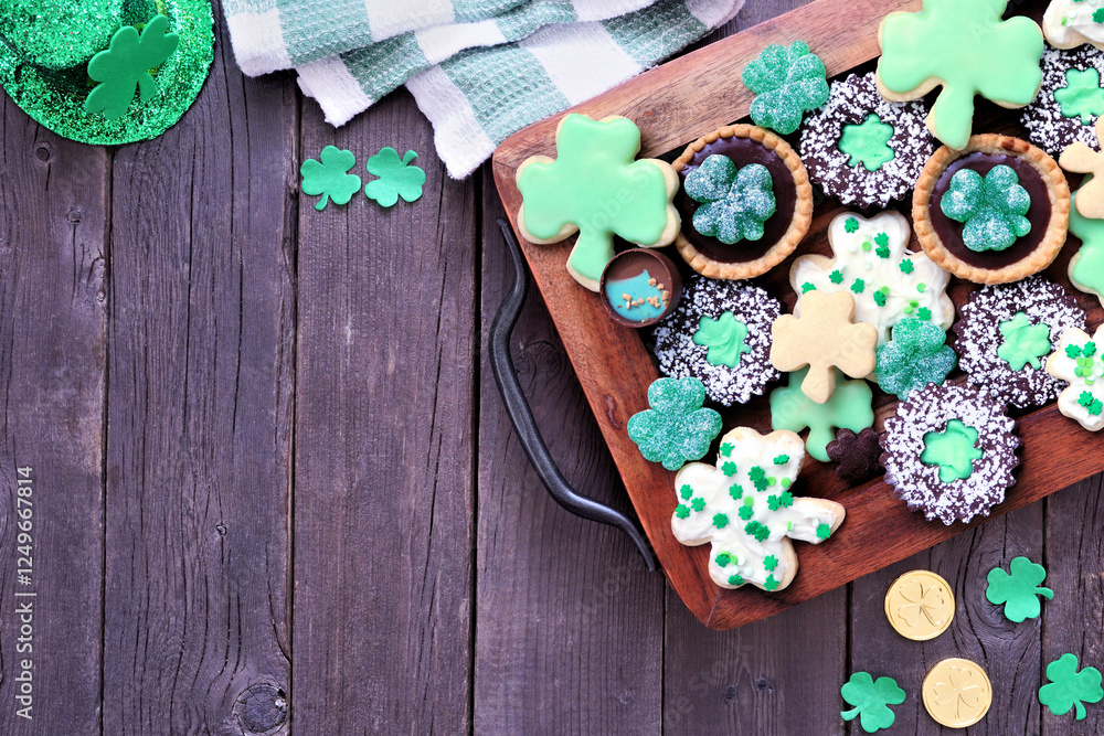 Poster St Patricks Day shamrock dessert board. Green cookies and sweets. Top down view table scene over a rustic wood background with copy space.