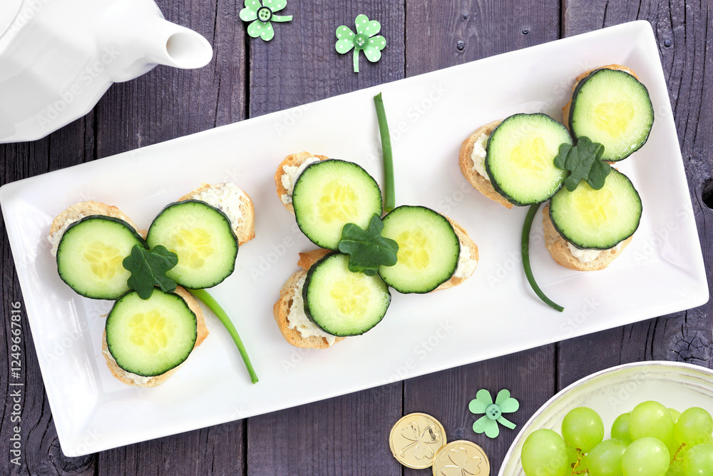Poster st patricks day shamrock open tea sandwiches with cream cheese and cucumber. above view table scene 