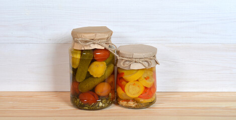 Glass Jars Of Preserved Vegetables on a table and wall.
