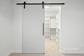 White door with a black handle is in front of a white closet