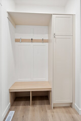 Small white room with a bench and a cabinet