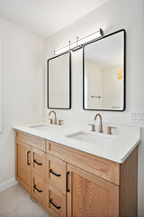 The bathroom is a modern design with two sinks and a mirror