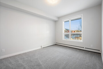 Large empty room with a window and a radiator