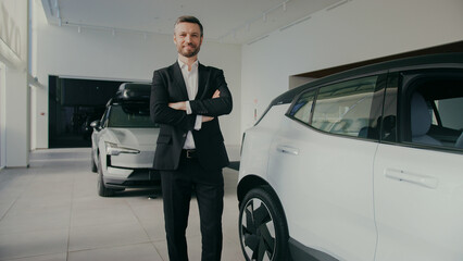 Stylish Caucasian male in business suit walking up and looking at camera while smiling. Man with...