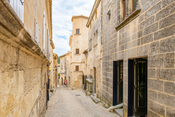 Obraz premium A typical narrow stone street through the historic medieval village of Les Baux-de-Provence in the Alpilles Mountains of the Provence-Alpes-Cote d'Azur region of Southern France. 