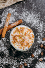 Creamy spiced milk drink in a stylish glass, topped with cinnamon and coconut flakes