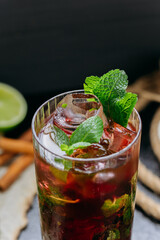 Refreshing hibiscus cocktail with lime, mint, and ice in a tall glass, summer and tropical vibes