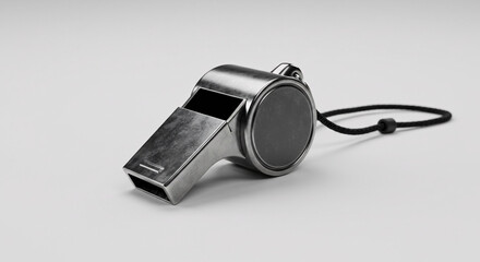 Metallic whistle with black cord on white background