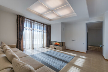 The sun rays on the floor of the living room with a modern interior. Soft ceiling lighting.