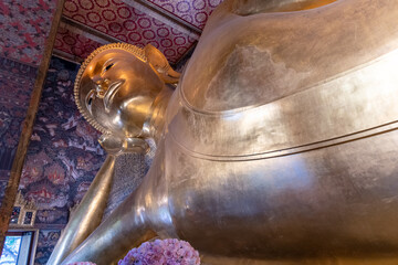 The magnificent Reclining Buddha at Wat Pho is located in vibrant Bangkok, Thailand