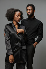 Elegant black couple in stylish outfits, capturing modern fashion expression with confident emotions and neutral background, perfect for lifestyle imagery