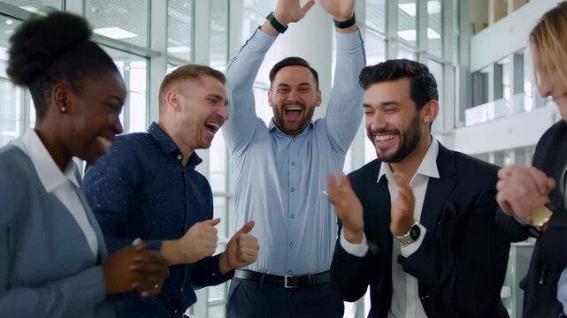 Enthusiastic business team celebrating success in modern office