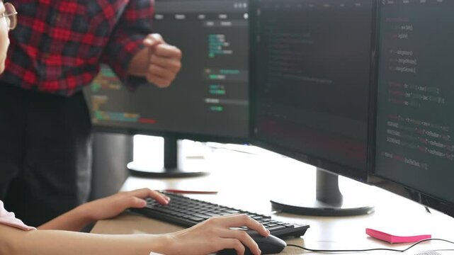 Slow motion back end or software developer manager supervising his team on new application program development on debugging and solving complex code algorithms on monitor. Burgeoning
