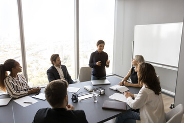 Young 30s Indian female trainer, team leader, company executive make speech in front of business...