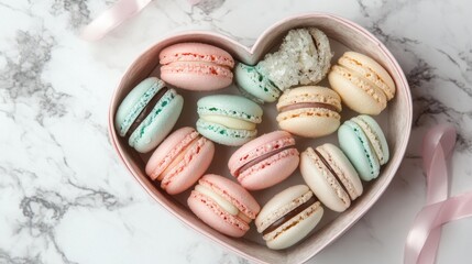 Fototapeta premium A heart-shaped box filled with pastel-colored macarons on a marble countertop.