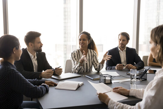 Young 30s African team leader make speech, hold meeting with shareholders, provide information, share opinion, talk about project details, corporate strategy, forecasting, brainstorming in boardroom