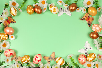 Abstract spring easter composition with golden painted eggs, feathers, butterflies, blossom branches and flowers. Happy easter concept. Screen banner with space for greeting text