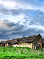 Obraz premium Large, old building with a lot of windows sits in a field