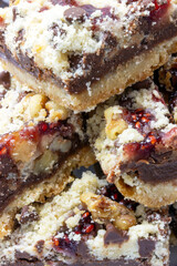 Bittersweet dark chocolate raspberry dessert bars with chopped walnuts on bottom layer of butter,...