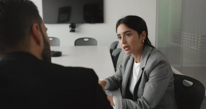 Two multiethnic businesspeople finalized terms on business deal, project, or partnership during their formal discussion or negotiations process, shaking hands, expressing mutual respect. Collaboration