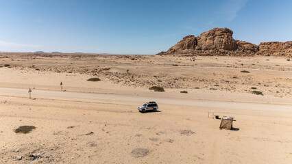 A 4x4 parked on the peak of a dune, taking in the vast desert view of Namibia