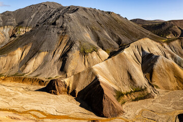 Vivid aerial view of colorful volcanic Landmannalaugar mountains and eroded terrain under clear sky, showcasing natural beauty and geological wonders. Perfect depiction for landscapes and travel