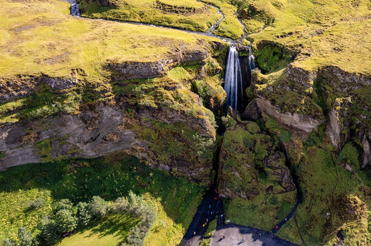 A magnificent aerial view Gljufrabui waterfall in Iceland plunges over the edge of green cliffs, surrounded by stunning countryside. The serene landscape captures beauty of untouched nature