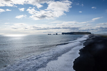 Obraz premium Aerail view a stunning black sandy beach Reynisfjara , sunset in Iceland VIK Myrdal in Golden Circle area with Atlantic Ocean waves crashing and volcanic rock formations